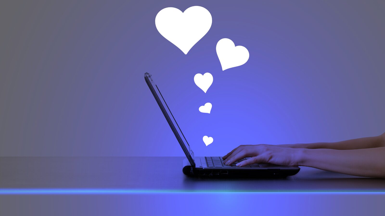 A laptop with heart symbols rising from the keyboard