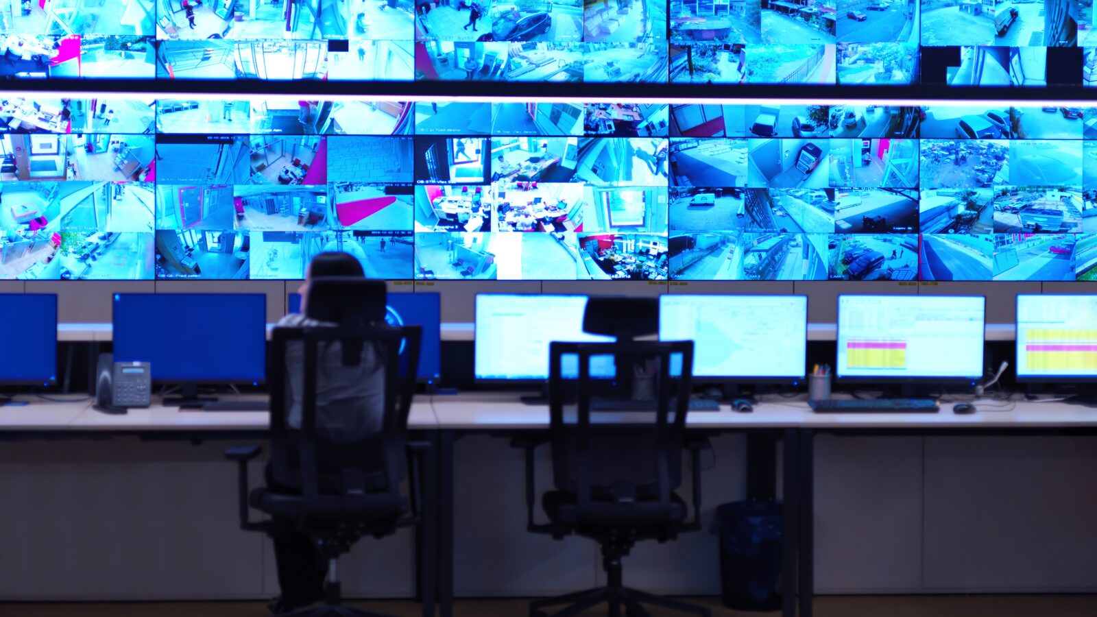 A monitoring control room with a wall of live screens
