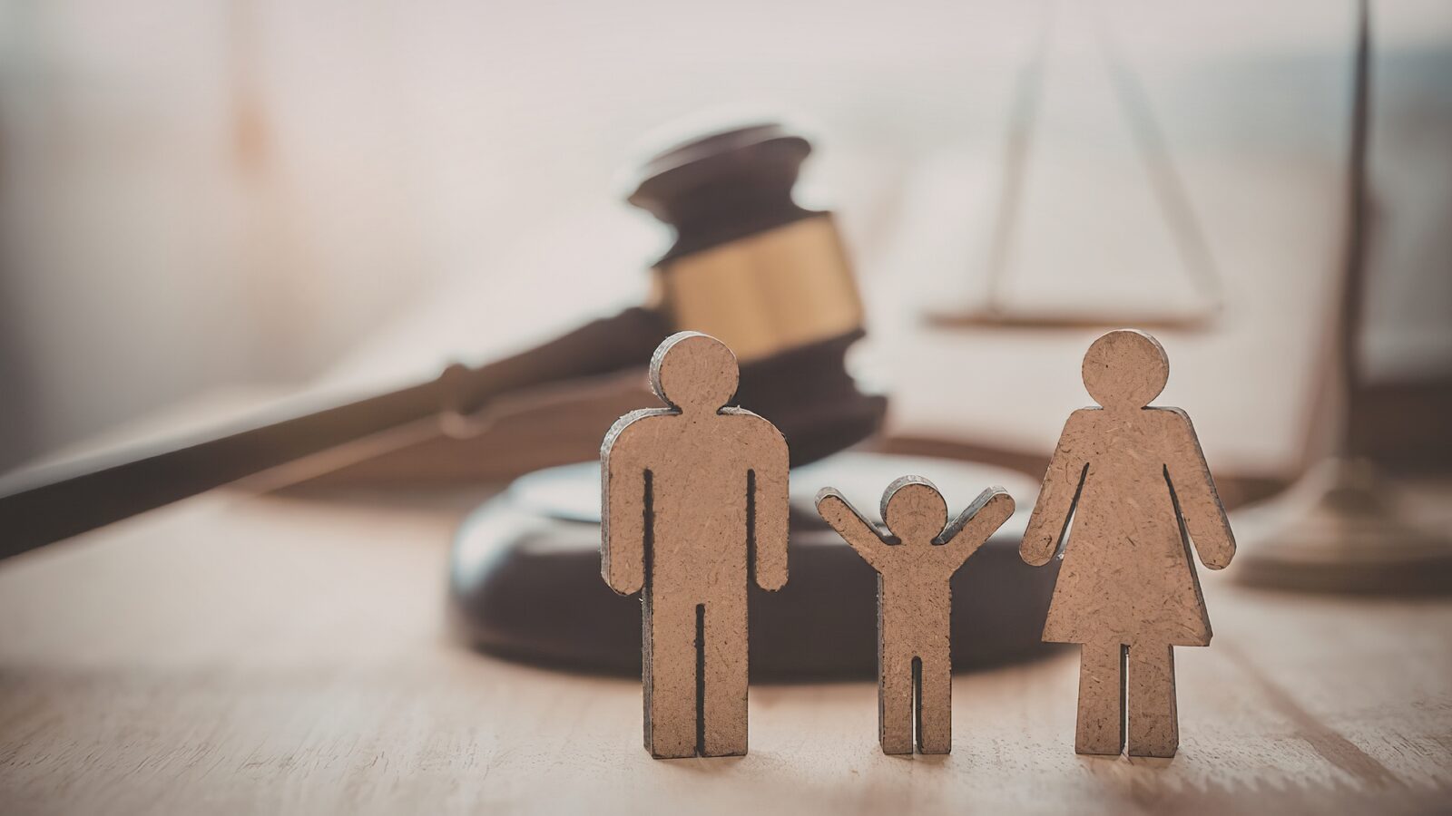 Wooden family figures beside a gavel, representing family court matters